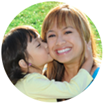 A young girl kissing her mother.